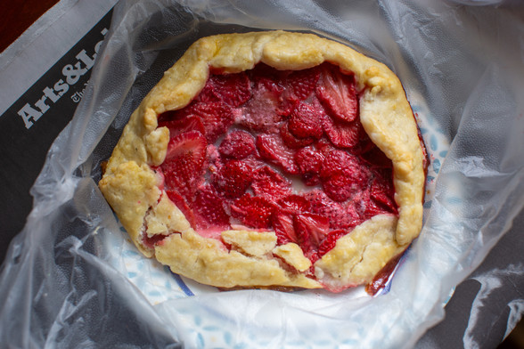 Small free-form tart with golden crust and filled with a layer of cooked strawberries.